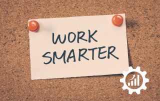 Zettel mit Work smarter auf einer Holzwand, bezogen auf die Effizienz Steigerung