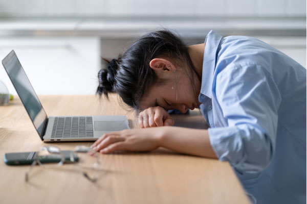 Erschöpfte Frau bei der Arbeit - burnout